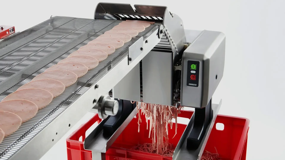 Machine industrielle de découpe de viande en fonctionnement dans un environnement de production alimentaire